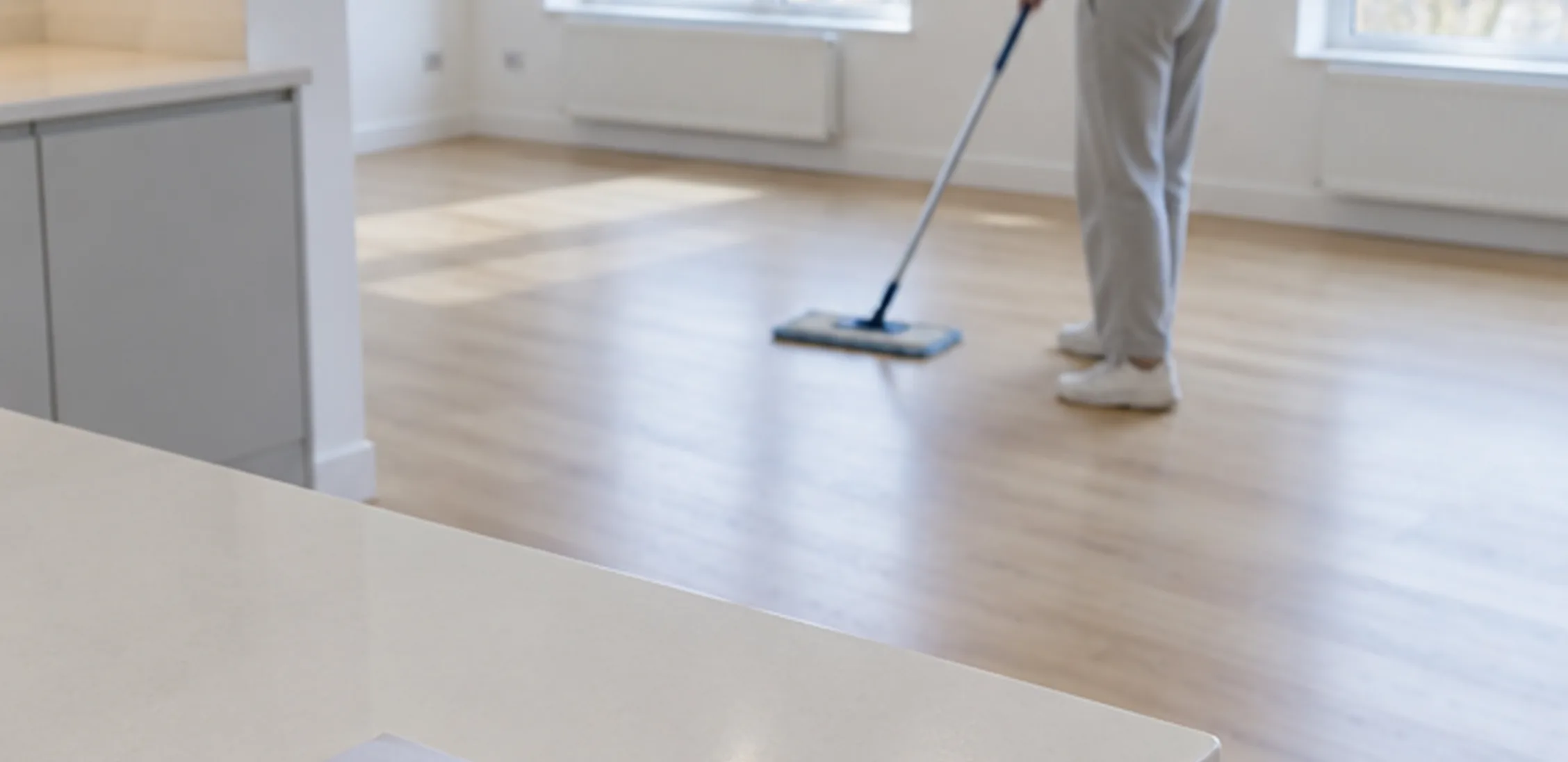 An empty flat being mopped, keys on the kitchen counter